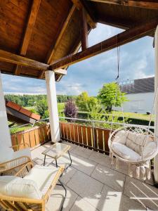 a porch with two chairs and a swing at Residenz Cheval - BOHO - Ravensburg - Bodensee in Ravensburg