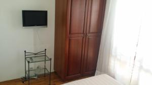 a bedroom with a wooden cabinet and a television at Villa Sandra Hvar in Hvar