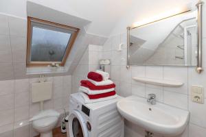 baño blanco con lavadora y lavamanos en Ferienwohnung Plogmann - Residenz Bernstein WHG 40, en Rerik