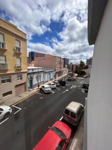 Un coche rojo está aparcado en una calle de la ciudad. en Padre Anchieta 35 - 2, en Santa Cruz de Tenerife