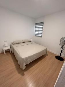 1 dormitorio blanco con 1 cama y ventilador en Padre Anchieta 35 - 2, en Santa Cruz de Tenerife