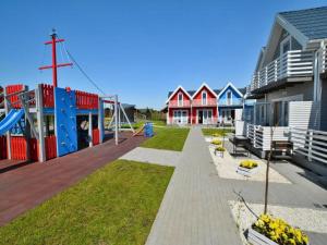 a playground in front of houses with a slide at Cottage in Sarbinowo near Seaside Beach in Sarbinowo