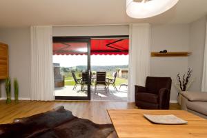 ein Wohnzimmer mit einem Tisch und Stühlen sowie eine Terrasse in der Unterkunft Ferienhaus Wiesenblick in Ahlbeck