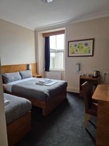 a hotel room with two beds and a window at Bank House in Inverness
