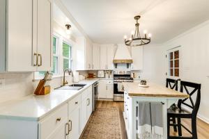 a kitchen with white cabinets and a large island at Alleghany Mountain Cottage with Porch and Backyard in Covington