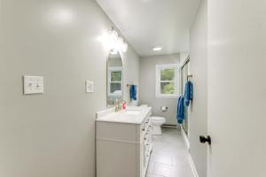 a white bathroom with a sink and a toilet at Alleghany Mountain Cottage with Porch and Backyard in Covington +24 photos
