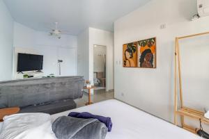 a living room with a bed and a flat screen tv at Vista para o Mar & Pé na Areia in São Vicente