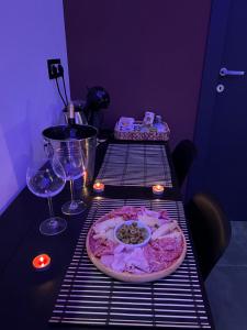 Una mesa con una pizza en una rejilla con copas de vino. en Il Casale del 900, en Catania