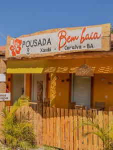 Un edificio con un cartel de bar con valla. en Pousada Bem Baia - Caraíva, en Caraíva
