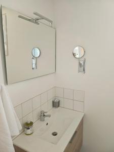 a white bathroom with a sink and a mirror at Maison Bois in Grosseto-Prugna +22 photos