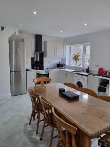 a large kitchen with a wooden table and chairs at 3 Bedroom House By The Sea, Deal Centre in Deal