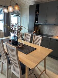 a kitchen with a wooden table with chairs and a dining room at Apartment vårstølen - myrkdalen skisenter in Vossevangen