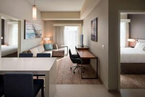 a hotel room with a bedroom and a desk and a bed at Residence Inn by Marriott Ventura Beach in Ventura