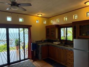 a kitchen with wooden cabinets and a white refrigerator at Finca Ometepe in Balgue