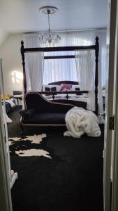奥克兰The Luxurious Manor - Very Large Bedroom with Private Ensuite的卧室里有一张四柱床，地板上铺着一条白色毯子