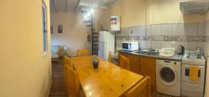 a kitchen with a wooden table and a washing machine at Las Palmeras de Lavalle in San José +13 photos