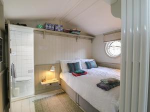 Un dormitorio pequeño con una cama y una ducha. en The Artist's Cabin By The Sea, en Herne Bay