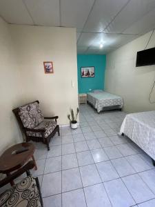 Habitación con 2 camas, sofá y silla en Habitación las brisas, en El Rosario 2 fotos más