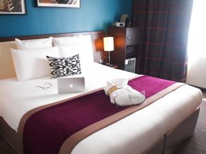 a bedroom with a large bed with a laptop on it at Mercure Angers Centre Gare in Angers