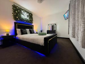 a bedroom with a large bed with blue lights at Mansa Halifax in Halifax +95 photos