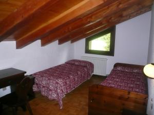 a bedroom with two beds and a window at Hotel Camping Grivola in Valsavarenche