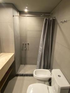 ein Badezimmer mit Dusche, Toilette und Waschbecken in der Unterkunft Edificio Pantera - monoambiente 7 in San Martín de los Andes + 9 Fotos