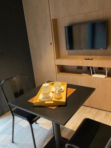 ein schwarzer Tisch mit zwei Tassen und einem gelben Tablett in der Unterkunft Edificio Pantera - monoambiente 7 in San Martín de los Andes