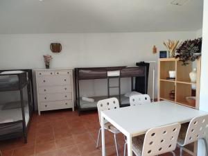 a room with a table and chairs and a bunk bed at Casas do Montinho in Melides