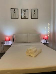 a white bed with two towels on it with two lamps at Fk homes executive studio with rooftop pool in Mtwapa +22 photos