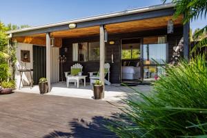 a house with a deck with a patio at Harbour View Cottage Bay of Islands in Opua