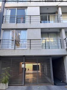 an apartment building with a garage with a gate at Temporary Rental in Chivilcoy