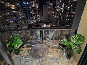 a balcony with a table and chairs on a building at Modern Studio Apartment near ICC On Dixon street in Sydney