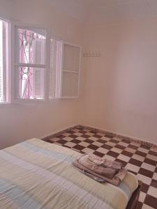 a bed in a room with a checkered floor at Casa olampika in Larache