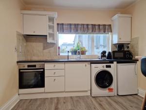 a kitchen with a sink and a washing machine at Killarney central apartments in Killarney