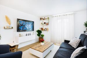 a living room with a couch and a coffee table at Maison Cosy Paisible avec Jardin in Livry-Gargan