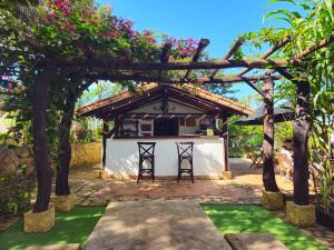 a pergola with two chairs and a table at Cabaña Las Chicharras in Barichara