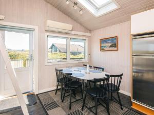 a dining room with a table and chairs and windows at 6 person holiday home in Hjørring in Lønstrup +33 photos