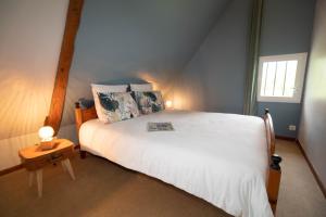 a bedroom with a large white bed and a window at Domaine des demoiselles - Chambres d'hôtes et Spa in Hauteville