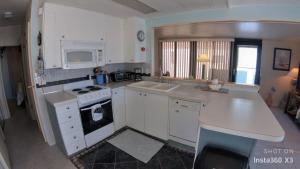 Una cocina con gabinetes blancos y un horno de estufa. en Coastal Adorable 1 bedroom 1 bath beach bungalow Located On Nettles Island, en Jensen Beach
