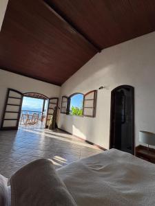 a bedroom with a bed and a view of the ocean at Casa Ilha Grande in Praia de Araçatiba +49 photos