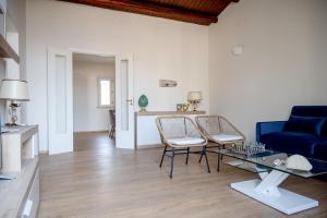 a living room with a blue couch and a glass table at Casa di charme "Al Moro Avola " in Avola +30 photos