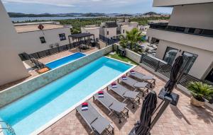 una vista dall'alto di una piscina su un edificio con sedie di Luxurious Home In Vodice With Sauna a Vodice Altre 39 foto
