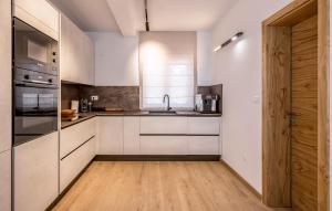 una cucina con mobili bianchi e pavimento in legno di Luxurious Home In Vodice With Sauna a Vodice