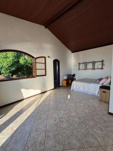 a bedroom with a bed and a large window at Casa Ilha Grande in Praia de Araçatiba