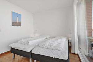 duas camas num quarto com um farol ao fundo em 790-Hvide-Sande-Ae-Gammel-Havn-49 em Hvide Sande