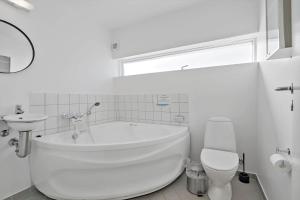 um banheiro branco com banheira e vaso sanitário em 790-Hvide-Sande-Ae-Gammel-Havn-49 em Hvide Sande mais 27 fotografias