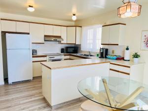 a kitchen with white cabinets and a glass table at Entire 6BED house easy to Banff & DT, Winsport in Calgary