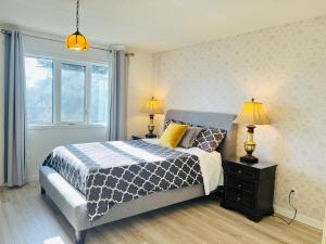 a bedroom with a bed and two lamps and a window at Entire 6BED house easy to Banff & DT, Winsport in Calgary