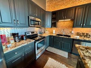 a kitchen with blue cabinets and a stove top oven at In the Heart of Town-3BR-2bath-500Mbps WiFi-4car parking-EV-boat in Florence +11 photos