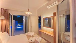 a hotel room with a bed and a mirror at Zorbas Family Villas in Skiathos Town +91 photos